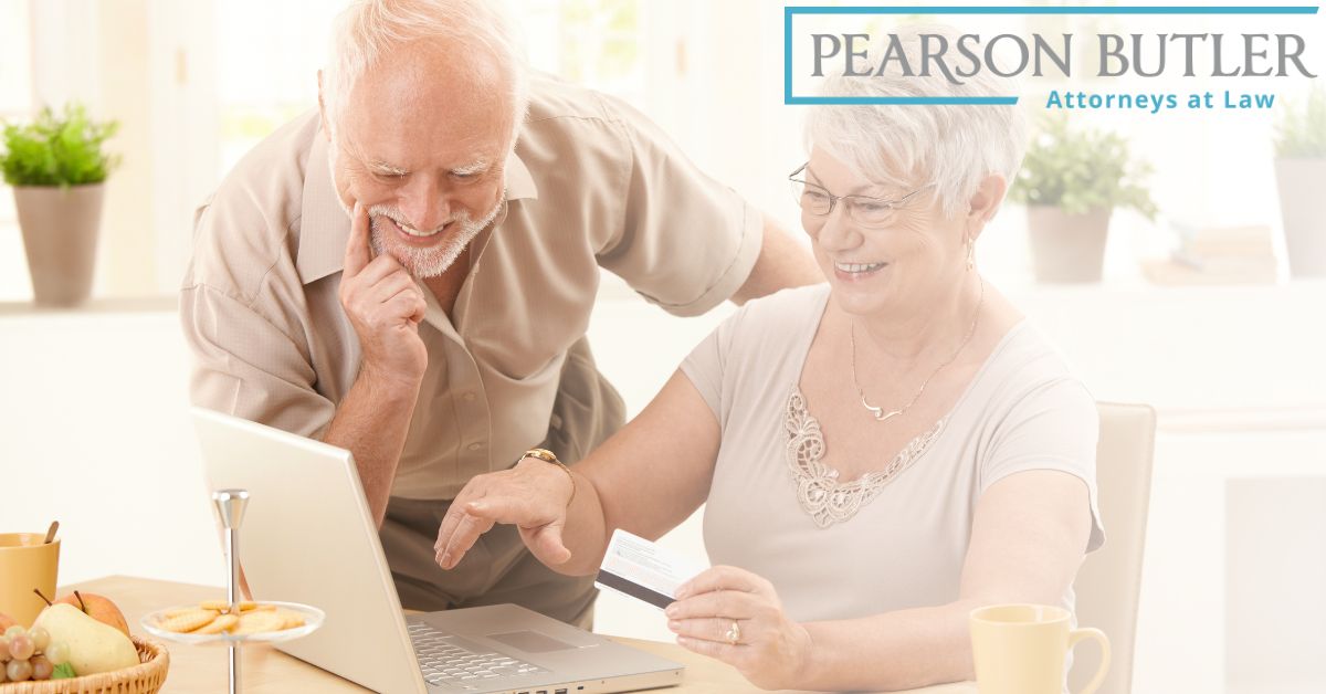 Elder couple smiling while looking at laptop